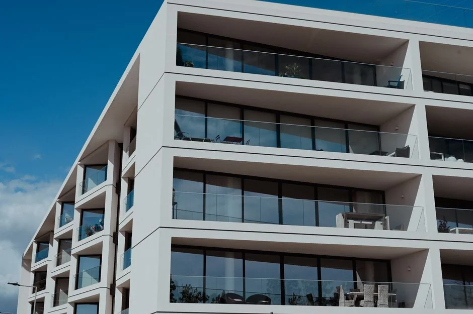 Des nettoyeurs de vitres professionnels à l’œuvre sur un gratte-ciel à Abu Dhabi, mettant en valeur l’architecture urbaine.